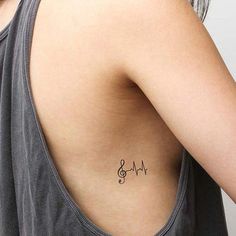 a woman with a heartbeat tattoo on her upper back shoulder and the word love written in cursive font