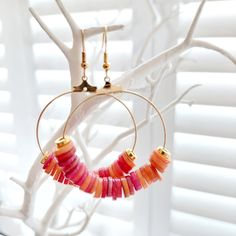 These gorgeous orange and gold Heishi hoop earrings are made from coloured natural freshwater shells, ideal for adding drama to any outfit! Perfect for a beach holiday or festival, wedding or special occasion! Hoops and earring hooks are made from plated gold.  Each pair of earrings has been handmade by Mizzle & Tink. Should you want a certain colour way or order of colours, please do get in touch as I can always make a bespoke pair! Earrings are packaged in a smart black earring box, like the o Trendy Gold Hoop Earrings For Beach, Trendy Gold Hoop Earrings For Vacation, Pink Hoop Earrings For The Beach, Handmade Hoop Earrings For The Beach, Orange Small Hoop Earrings For Summer, Handmade Red Hoop Earrings For Beach, Red Bohemian Hoop Earrings For Beach, Handmade Small Hoop Earrings For Vacation, Bohemian Red Hoop Earrings For Beach