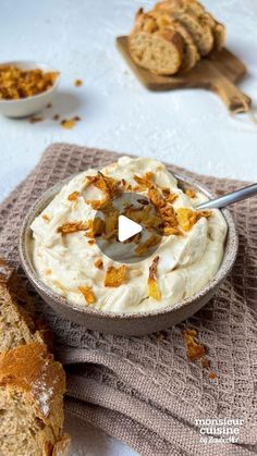 an image of a bowl of food with bread on the side and another dish in the background