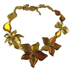 JEAN LOUIS SCHERRER gorgeous vintage gold toned necklace featuring textured bows, leaves and flowers embellished with orange/yellow resin cabochons. Panther head spring clasp. Adjustable length. Marked SCHERRER Paris Made in France. Indicative measurements : adjustable length from approx. 52.5 cm (20.67 inches) to approx. 57 cm (22.44 inches) / largest flower approx. max. 7 cm x max. 7 cm (2.76 inches x 2.76 inches). NOTES - This is a preloved vintage item, therefore it might have imperfections. Jean Louis Scherrer, Panther Head, Yellow Resin, Gold Scarf, Cluster Necklace, Station Necklace, Floral Necklace, Gold Tone Necklace, Pearl Choker