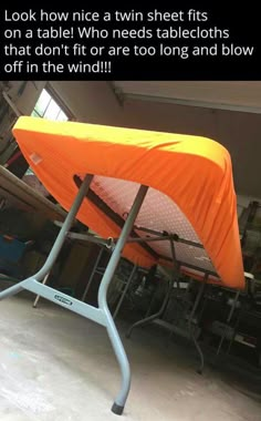 an orange tent sitting on top of a metal stand