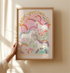 a person holding up a poster in front of a window that says magic unicorn club