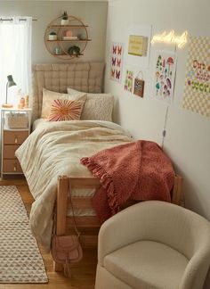 a bed room with a neatly made bed next to a chair and a rug on the floor