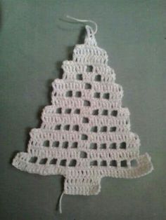 a crocheted christmas tree ornament hanging on a wall