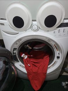 a washing machine with two eyes on it's front and the door open to show its contents