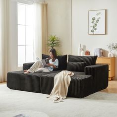 a woman sitting on a couch reading a book