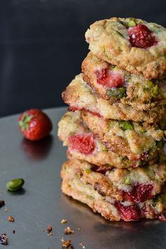 three cookies stacked on top of each other next to a strawberry and pistachio