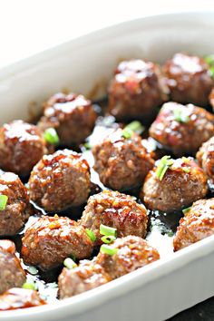 meatballs with sauce and scallions in a casserole dish