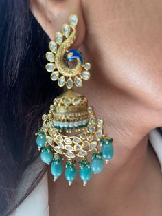 Discover the beauty of these traditional gold-plated Kundan jhumkis, featuring intricate designs and elegant peacock motifs. Adorned with mint green bead drops, these jhumkas add a touch of elegance to any outfit. Perfect for festive occasions or special events, these earrings beautifully blend traditional craftsmanship with modern style. Earrings are Approximately 3.6 inches Long and 1 inch Wide  Our products are meticulously handcrafted, ensuring each piece is unique. Due to the manual craftsm Earrings Kundan, Peacock Motifs, Princeton Nj, Peacock Earrings, Green Pearls, Peacock Design, Intricate Designs, Style Earrings, Green Bead