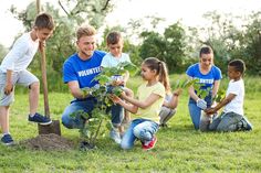 a group of children and adults planting trees