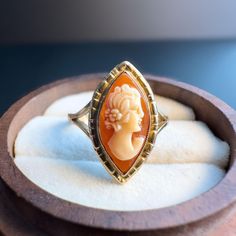 This stunning 9ct gold vintage cameo ring is a timeless piece of art, featuring a beautifully hand-carved cameo in an elegant marquise-shaped setting. The delicate portrait, carved with exceptional detail, showcases the profile of a classical lady figure. The warm tones of the natural shell cameo contrast beautifully against the gleaming 9ct gold band, highlighting the craftsmanship and vintage charm of this piece. The intricate gold setting adds a sophisticated touch, making it the perfect stat Cameo Ring, Vintage Cameo, Carved Shell, Classic Ring, Gold Set, Gold Band, Statement Ring, Rings Statement, Vintage Charms