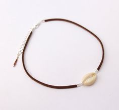 This choker necklace is made whith genuine brown leather lace adorned with a white cowrie shell.------ ▲ ▲ ▲ ------SIZE:> Chain length: 31 cm (36 cm with the little chain)Closing-system : AdjustableMATERIAL:> genuine leather> Silver plated metal> Cowrie shellNickel free jewelry !COLOR:> Brown> White> Silver------ ▲ ▲ ▲ ------Comes in its own handmade gift package, ready to be given as a present. (If you want to).------ ▲ ▲ ▲ ------Follow me:> Facebookhttp://facebook.com/sarayana.fr> Official sit Handmade Brown Choker For Beach, Bohemian Brown Cowrie Shell Jewelry, Beach Brown Choker Necklace, Brown Choker Necklace For The Beach, Brown Choker Necklace For Beach, Brown Necklace For Summer Festivals, Lace Choker Necklace, Festival Necklace, Cowrie Shell Necklace