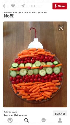 a platter with carrots, cucumbers and cherries arranged in the shape of a face