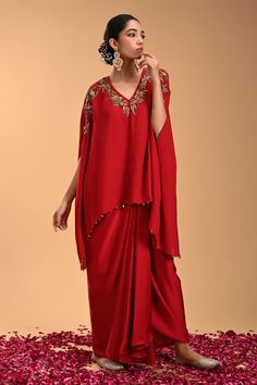 Red asymmetric tunic with floral embroidery and beaded hem. Paired with a draped dhoti style skirt. - Aza Fashions Elegant Red Kaftan With Floral Embroidery, Red Hand Embellished Traditional Drape Sets, Red Embellished Kaftan With Traditional Drape, Traditional Red Draped Dresses, Festive Red Kaftan With Floral Embroidery, Festive Draped Sets With Floral Embroidery, Dhoti Skirt, Asymmetric Tunic, Tunic Pattern