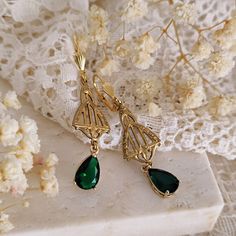 These art deco teardrops earrings are made of raw brass and emerald green glass stones and have an exquisite art deco design. The teardrop crystals have an intense emerald green color and they are set in 14k gold plated brass settings. The shell shaped 14k gold plated lever backs are connected to raw brass elements with gorgeous art deco style details. The earrings measure 5.8 cm (approx. an inch) in length. These earrings come packaged in a kraft paper gift box with cute, handmade details. SHIP Stile Art, Design Art Nouveau, Art Deco Emerald, Emerald Green Color, Brass Hoops, Art Nouveau Design, Paper Gift Box, Silver Jewels, Garnet Earrings