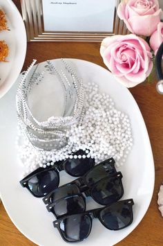 some pearls and sunglasses on a white plate