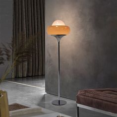 a lamp that is on top of a table next to a couch in a room