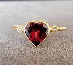 1. Garnet 18k Gold Ring 2. Stamped 3. Gemstone - Garnet, Diamond  4. Jewelry Type - Gold Ring 5. Total Weight - 1.560 Grams Approx. 6. Garnet Weight - 1.56 Carats 7. Diamond Weight - 0.04 Carats  8. Gold Weight - 1.240 Grams Approx. 9. Garnet Size - 7x7 MM 10. Gold Purity - 18k 11. Band Size - 1 MM 12. Handmade Items 13. AAA Quality Ring 14. Stackable Ring 15. 1 Quantity Available 16. Ready to Dispatch in 1 - 2 days. 17. Natural Red Garnet   Pictures are taken under natural and day light. Yellow Gold Heart-shaped Jewelry With Halo Setting, Yellow Gold Heart Jewelry With Halo Setting, Heart-shaped Yellow Gold Jewelry With Halo Setting, Yellow Gold Jewelry With Heart Shape Halo Setting, Luxury Heart Cut Ruby Ring, Luxury Red Heart Ring For Valentine's Day, 14k Gold Heart Cut Red Jewelry, Red 14k Gold Heart Cut Jewelry, Heart-shaped Ruby Ring For Formal Occasions