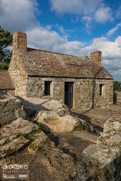 an old stone building sitting on top of a rocky hillside