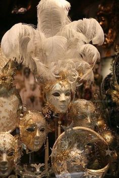 masks and feathers on display in a store window