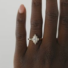 a woman's hand with a diamond ring on top of her finger, showing the center stone