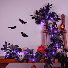 halloween decorations with purple lights and skulls on a wooden bench in front of a white wall