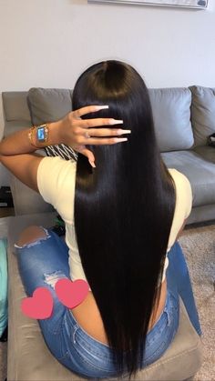 a woman is sitting on the floor with her long hair in front of her face