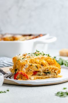 a white plate topped with lasagna covered in cheese