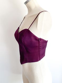 Delicious, regal dark violet fitted bustier with straps. Side zips. A rare, nearly perfect thing of beauty. Made in Italy. Fabric: Wool with acetate liningLabel: Moschino CoutureFit: SEra: 1990’s Measurements: Bust 34"Under bust 27"Between straps 9" Length (side) 7"Strap drop (shoulder to top) 6" Condition: Very good. One strap is twisted (i.e. doesn't lay flat) and one small hole in front outer covering (see photo). Elegant Corset With Adjustable Straps For Party, Elegant Party Corset With Adjustable Straps, Party Underbust Bodice With Straps, Fitted Corset With Straps For Party, Fitted Straps Corset For Party, Fitted Purple Corset With Boned Bodice, Elegant Party Bodice With Straps, Party Bodice With Straps And Sleeveless Design, Party Bodice With Sweetheart Neckline And Straps