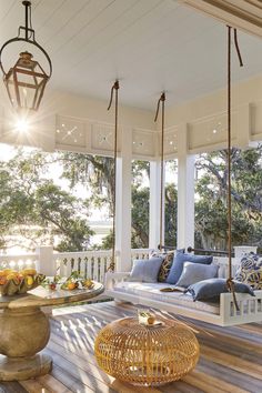 a porch with swings and pillows on it