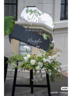 a wedding sign with flowers and greenery in front of a mirror that says welcome to the bride