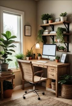 a desk with a computer and some plants on it in front of a large window