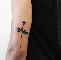 a woman's arm with a small rose tattoo on the left side of her arm