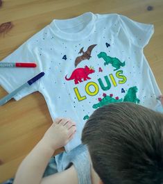 Looking for the perfect gift for your young Dinosaur lover's birthday? Look no further than our personalised dinosaur colour-in t-shirt! Made from high-quality, soft cotton, this t-shirt features a fun and engaging dinosaur design that your child will love. Plus, with the included fabric markers, your child can customise the shirt with their favorite team colors or designs. Our t-shirt is available in a range of sizes, from toddler to youth, so your child can enjoy it for years to come. And beca White T-shirt With Dinosaur Print For Birthday, Birthday Look, Love Plus, Dinosaur Coloring, Dinosaur Design, Fabric Markers, Dinosaur Birthday, Kids Tops, Team Colors