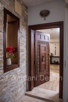 an entry way with a wooden door and decorative window frames on the brick wall behind it