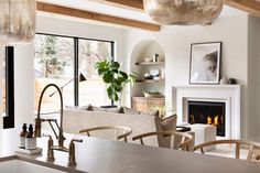 a living room filled with furniture and a fire place next to a kitchen counter top