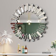 a mirror that is on the wall above a table with some bottles and vases