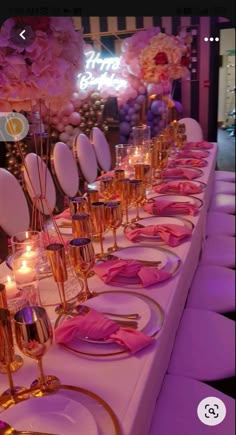 a long table is set up with pink napkins and place settings