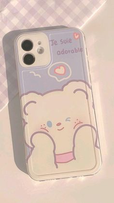 an iphone case with a cartoon bear on the front and back cover, sitting on a table