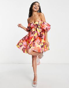 a woman in a colorful dress posing for the camera