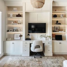 a living room with white furniture and built - in shelving