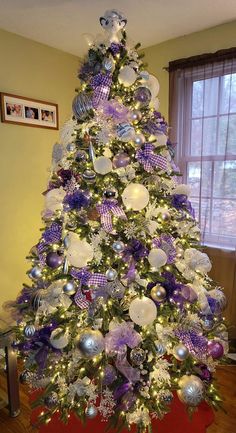 a christmas tree decorated with purple and silver ornaments