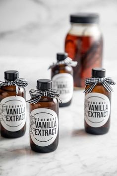 four jars filled with vanilla extract sitting on top of a table