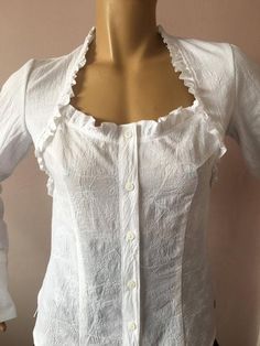 This white cotton shirt has the perfect body fit.The square neck ,embroidered front and gentle ruffles makes it feminine and playful.Can wear it with skirt or jeans for every day or add a little scarf to finish the look for the office.SIZE CHARTSIZE S - US 6, UK 8, EU 36bust: bust around 34.5”/90cmWaist: waist around 27.5”/70cmHips: hips around 34.5”/90cmSIZE M - US 8, UK 10, EU 38bust: bust around 37.5”/95cmWaist: waist around 29.5”/75cmHips: hips around 37.5”/95cmSIZE L - US 10, UK 12, EU 40bu Fitted White Shirt With Ruffles, Fitted Shirt With Ruffled Collar In Feminine Style, Fitted Cotton Blouse With Ruffles, Feminine Fitted Shirt With Ruffled Collar, Fitted White Shirt With Ruffled Collar, White Fitted Shirt With Ruffled Collar, Square Neck Cotton Tops With Ruffles, White Fitted Feminine Shirt, Fitted Feminine White Shirt