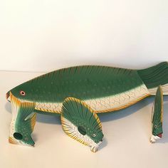 a green fish statue sitting on top of a white table