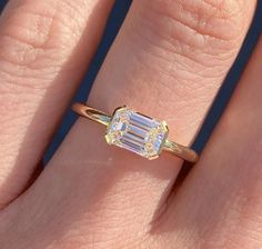 a woman's hand with a yellow and white diamond ring on top of her finger