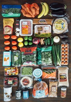 an assortment of food is laid out on a wooden table, including carrots, broccoli, peas, and other vegetables