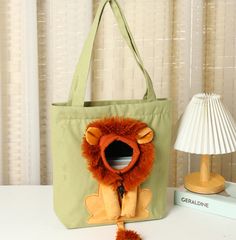 a bag with a lion on it sitting next to a lamp and a stuffed animal