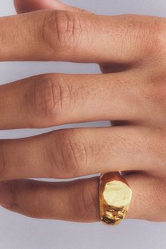 a person's hand with a gold ring on it