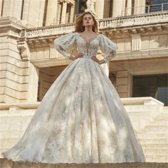 a woman in a wedding dress standing on some steps